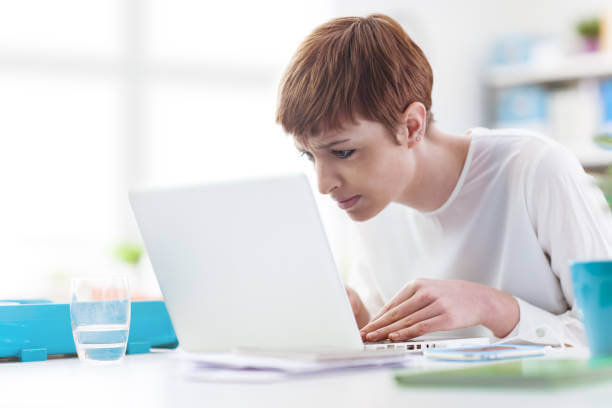 woman that has loss of vision looking thoroughly in her laptop screen