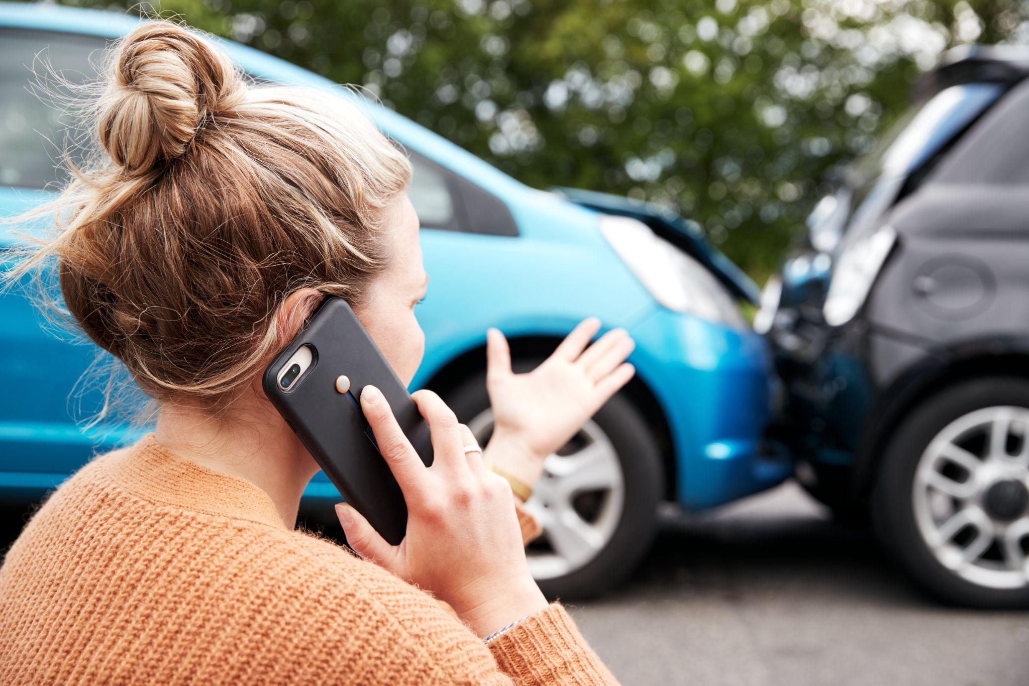 Woman on the phone after being involved in a fender bender